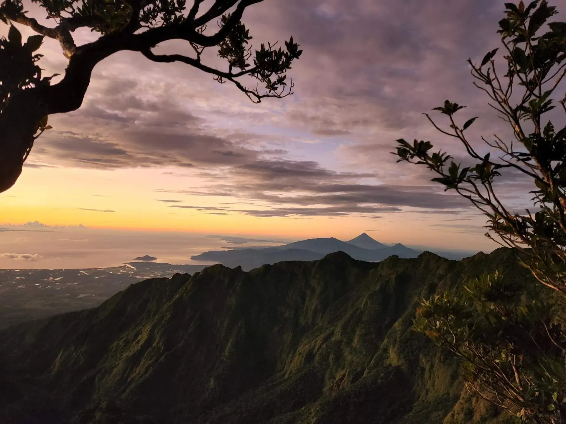 Sunrise over Bicol mountain ridges and a distant volcano